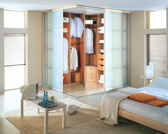 Отделить гардеробную от комнаты можно с помощью раздвижных дверей из стекла или дерева